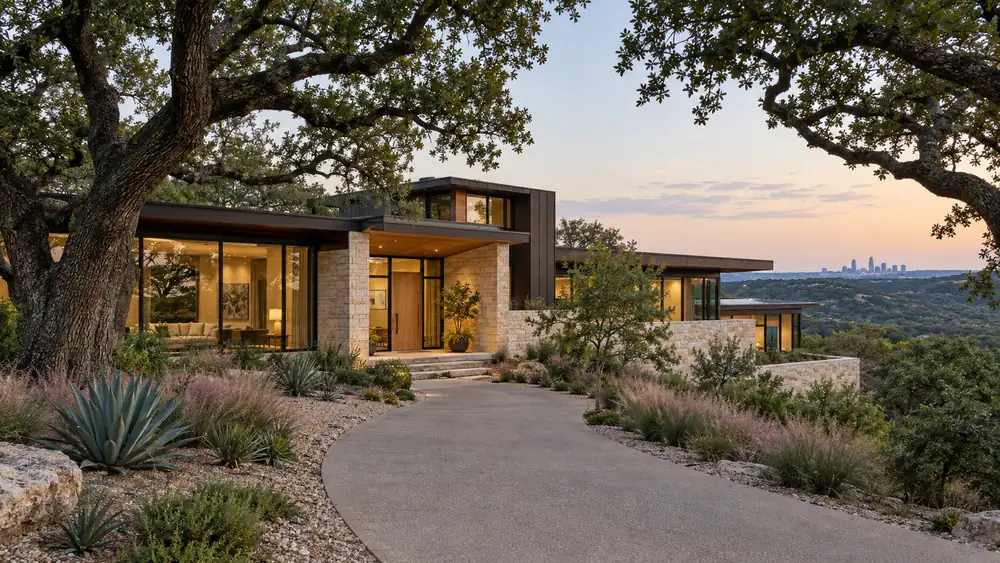 Hill country modern home among live oaks in West Lake Hills, Texas, with the Austin skyline in the distance